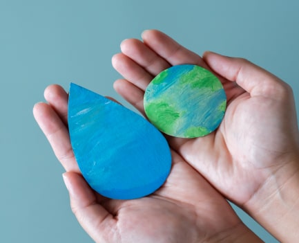 hands holding earth and water drop concept of save